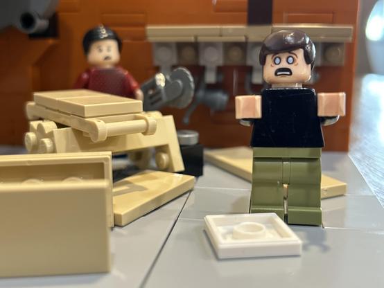 A very close picture of a Lego set with two minifigures. One is working at a set of sawhorses with a circular saw with a concerned look on his face. The other is standing with a completely shocked expression. Why he's shocked, I couldn't tell you, everyone has all their limbs.