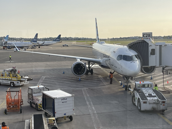 Morning light touches an airplane as it’s parked at the gate