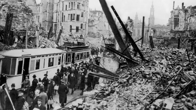 People stood next to a tram amongst rubble and collapsed buildings in Dresden, 1945 | Credit: Getty Images