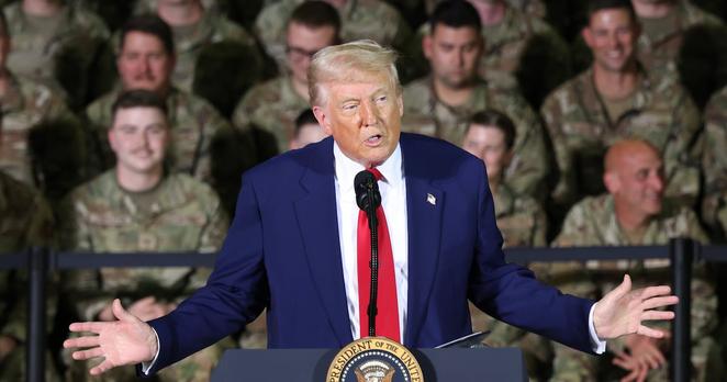 President Trump speaks while Michigan Air National Guard troops stand behind him.