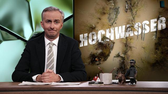 Jan Böhmermann sitzt am Schreibtisch. Rechts neben ihm steht das Wort "Hochwasser".