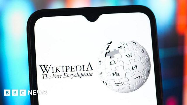 A stock image showing a screenshot of Wikipedia's logo - a globe constructed out of jigsaw piece like elements bearing letters in different global alphabets -  on a mobile phone. The text in the image reads "Wikipedia The Free Encyclopedia"