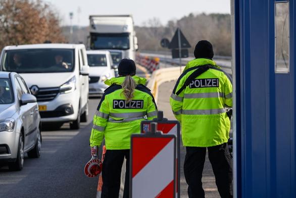 Beamte der Bundespolizei stehen bei der Einreisekontrolle am deutsch-polnischen Autobahngrenzübergang A15 bei Forst und beobachten die Fahrzeuge.