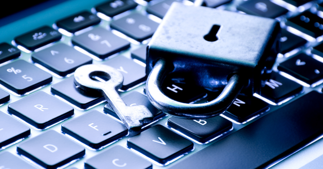 A padlock and key sitting on a laptop keyboard