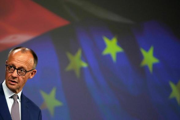 Merz vor einer EU-Flagge Merz vor einer EU-Flagge