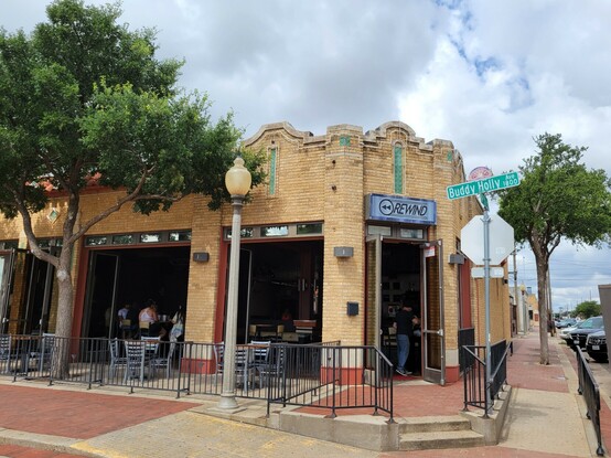 A one story ornate brick building with a bar, on Buddy Holly Ave.