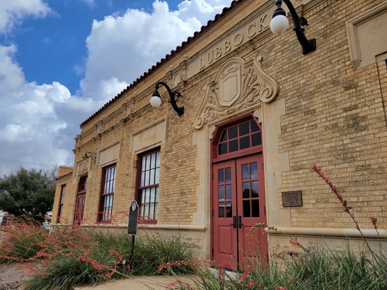 An ornate one-story brick building with a stone sign above the door saying "LUBBOCK."