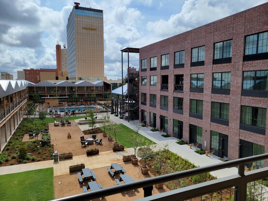 A courtyard surrounded by buildings, with a Wells Fargo skyscraper in the background.
