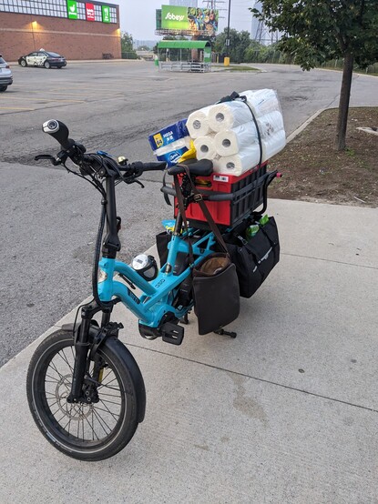 A blue cargo bike loaded with all the groceries from the cart. Cargot Robbie #carryshitolympics 