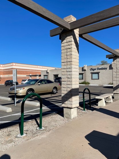 Forest green single hoop bike racks installed in front of Okun Dentistry.
