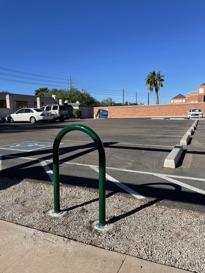 Forest green single hoop bike rack installed.