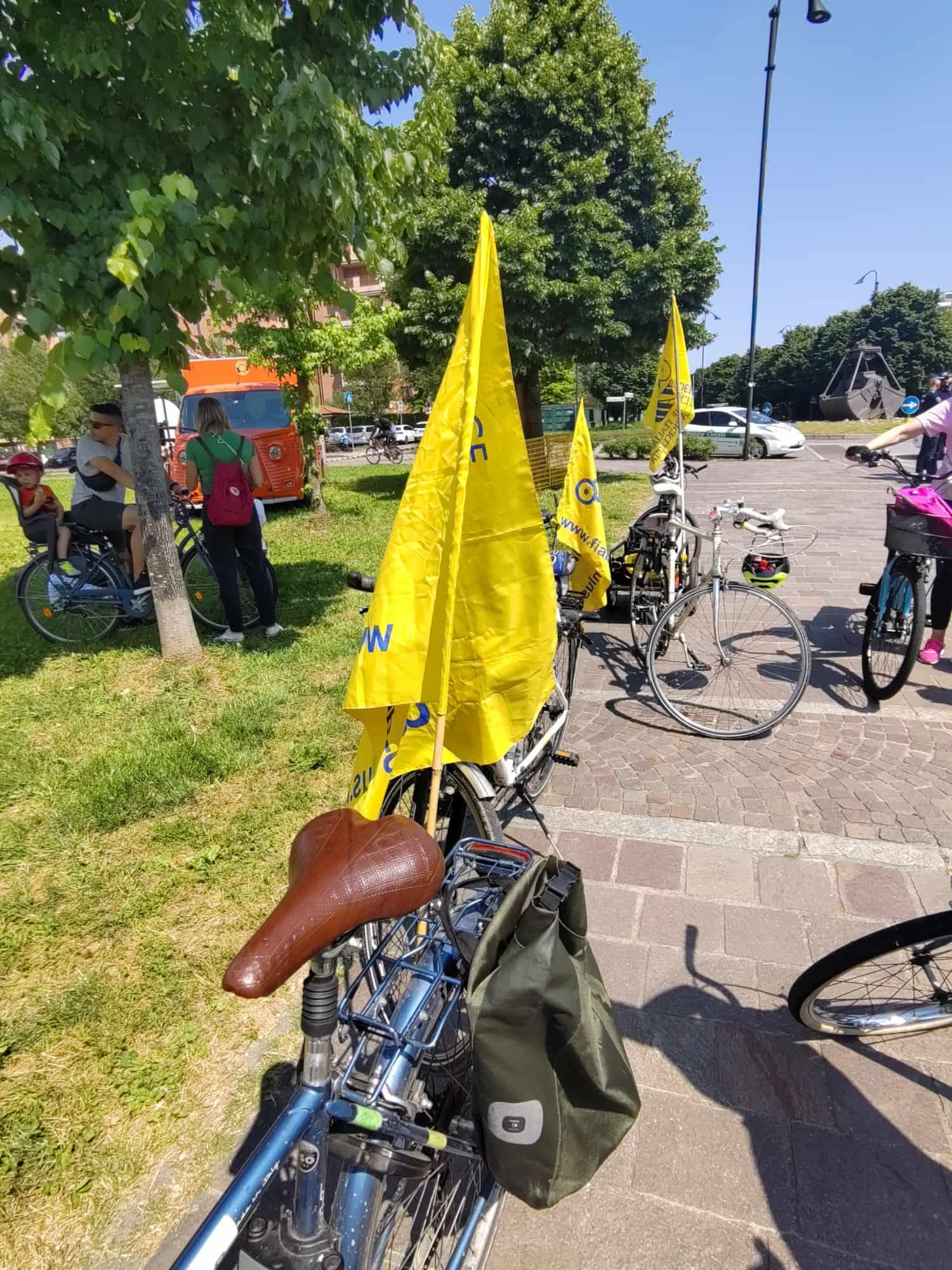 Alcune bici con le bandiere gialle di fiab allineate in un parco e pronte per la partenza