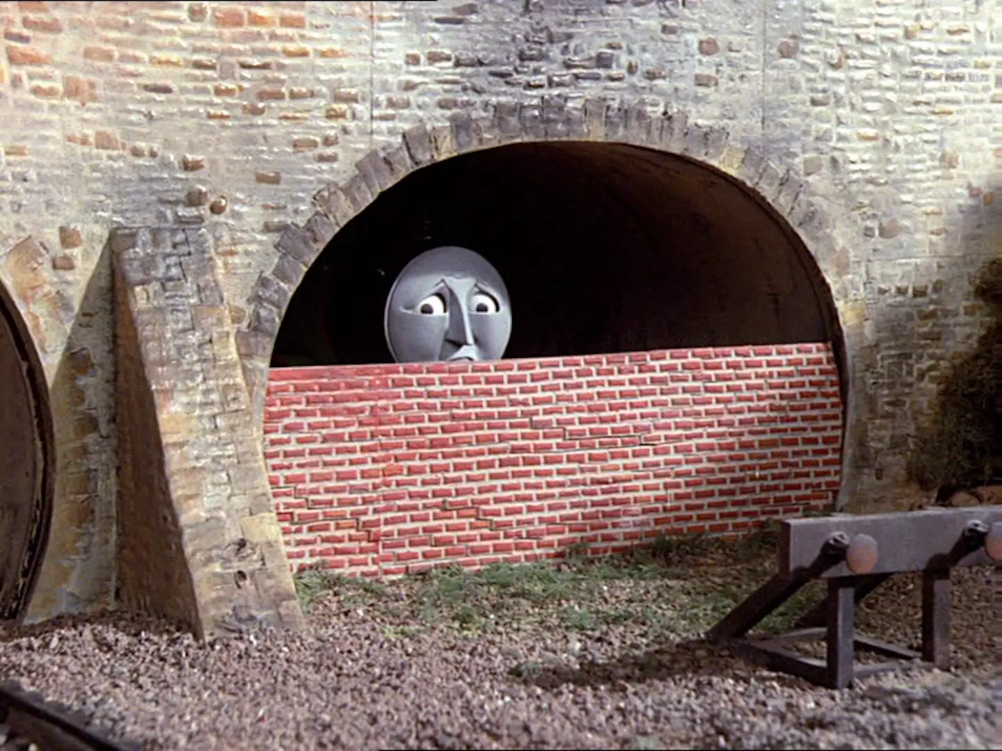 Henry the train from Thomas the Tank Engine halfway bricked up under a bridge span