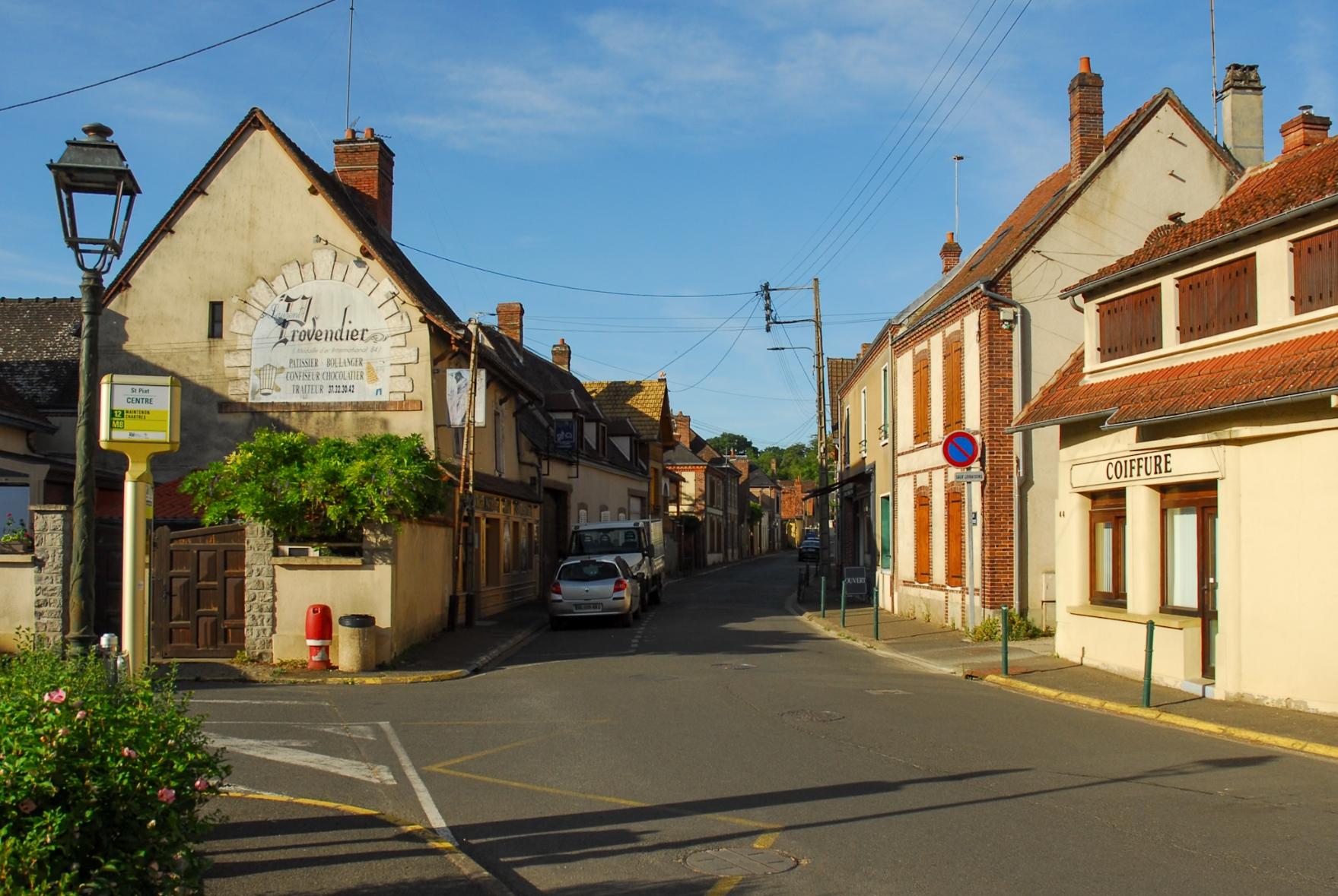 View down the tiny high street. A huge painted logo on the house to the left indicates that this is the village's Boulangerie.