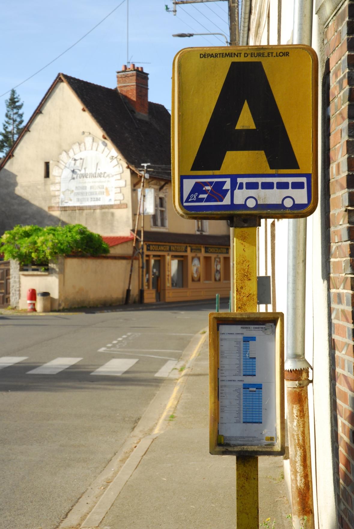 An old bus Stop sign. A yellow board with a huge black "A" on it, below a blue rectangle with a bus symbol and the logo of Eure-et-Loire - not actually a design masterpiece...