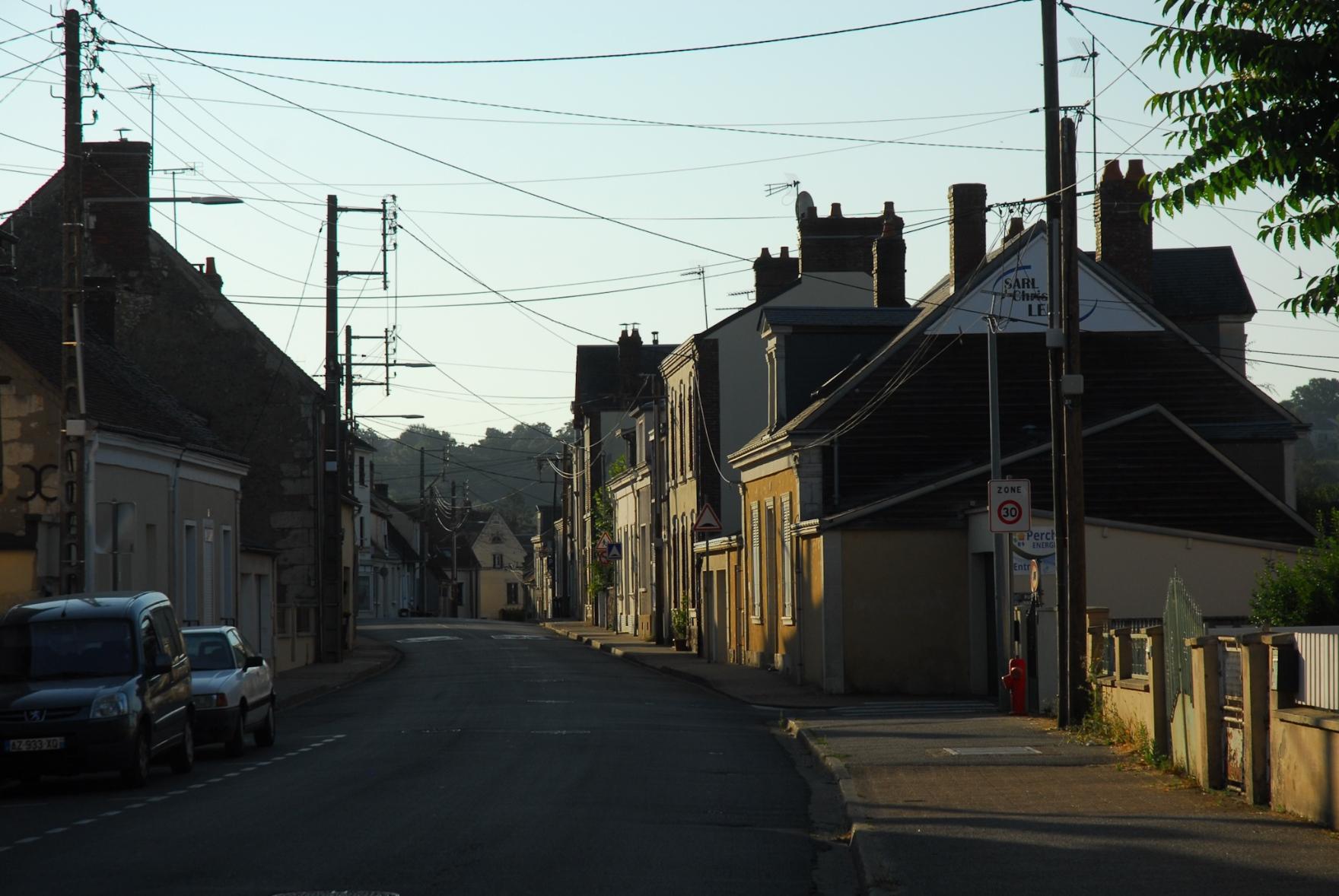 A street in town. To storey buildings lit up by the first sunlight of the day