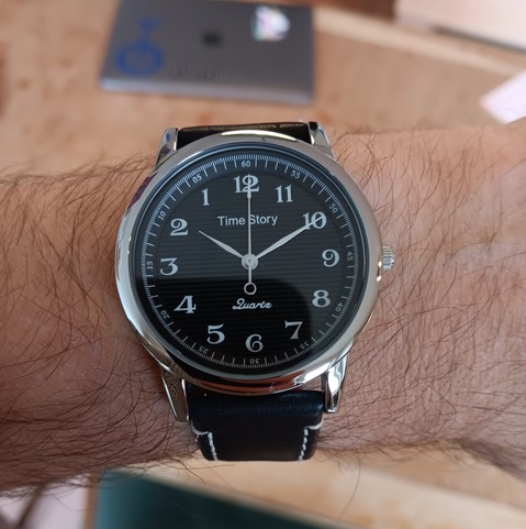 Watch with a numbers running counter clockwise. The time displayed is 1:50