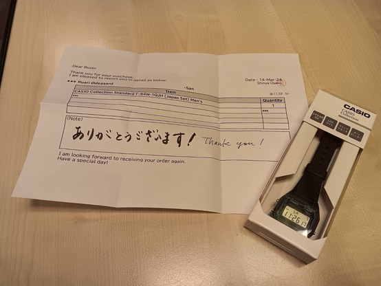 Picture of a new Casio F-84W in box, along with a note to the buyer [me]. The hand written part reads, "ありがとうございます! Thank you!"