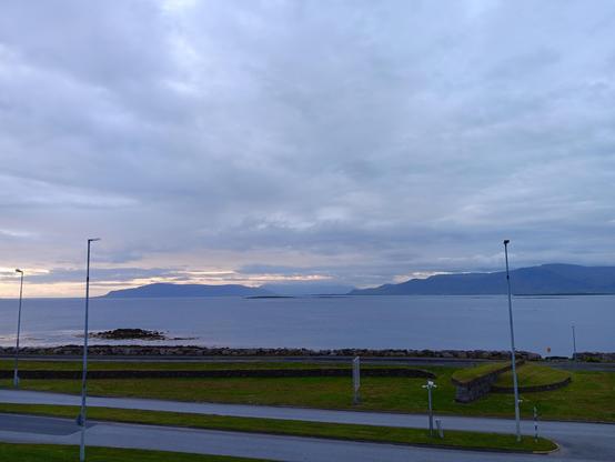 A view out over water in the evening with a slightly moody sky but still plenty of light. 