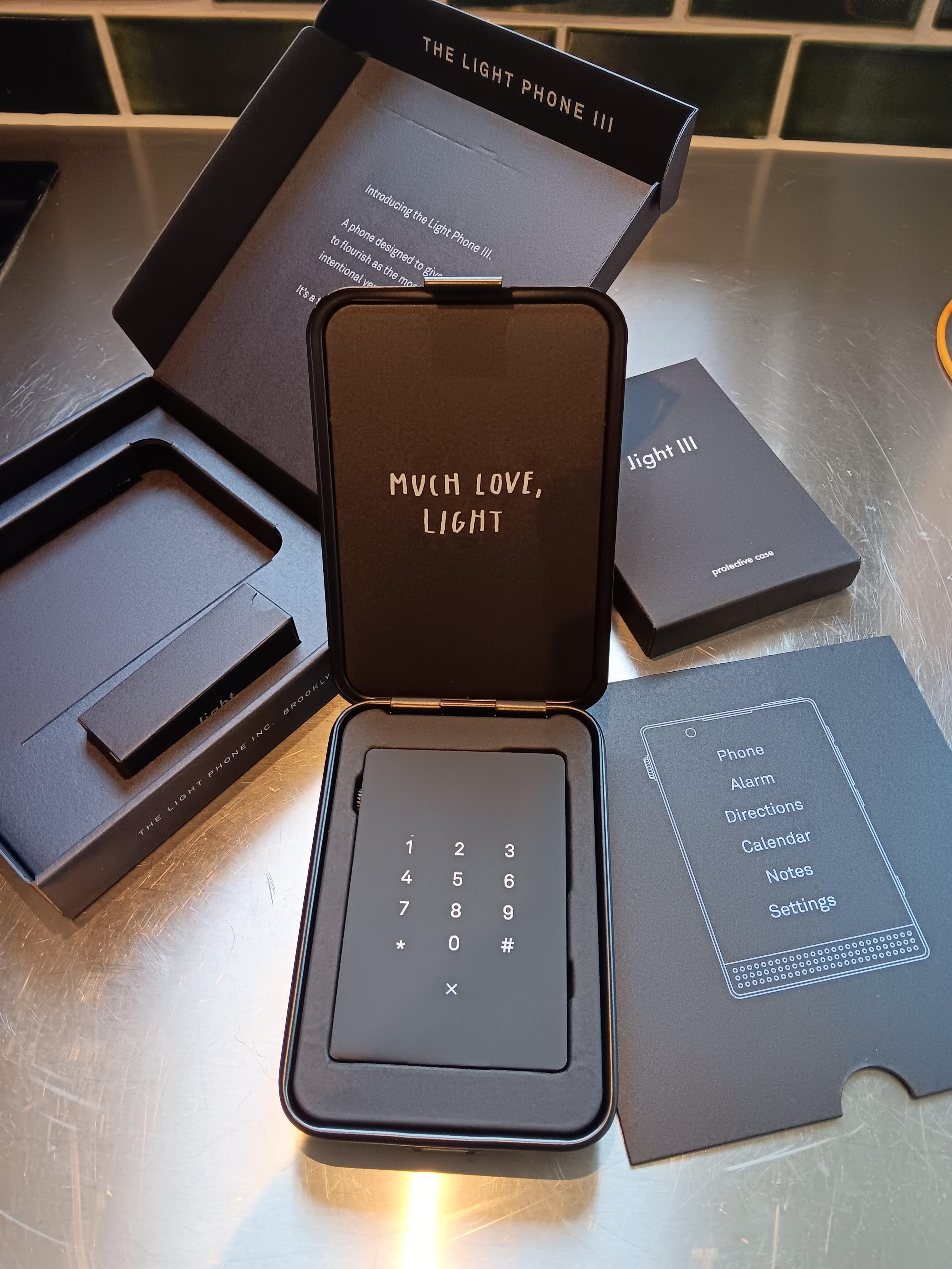 Tin opened to show the lightphone in yet more packaging.