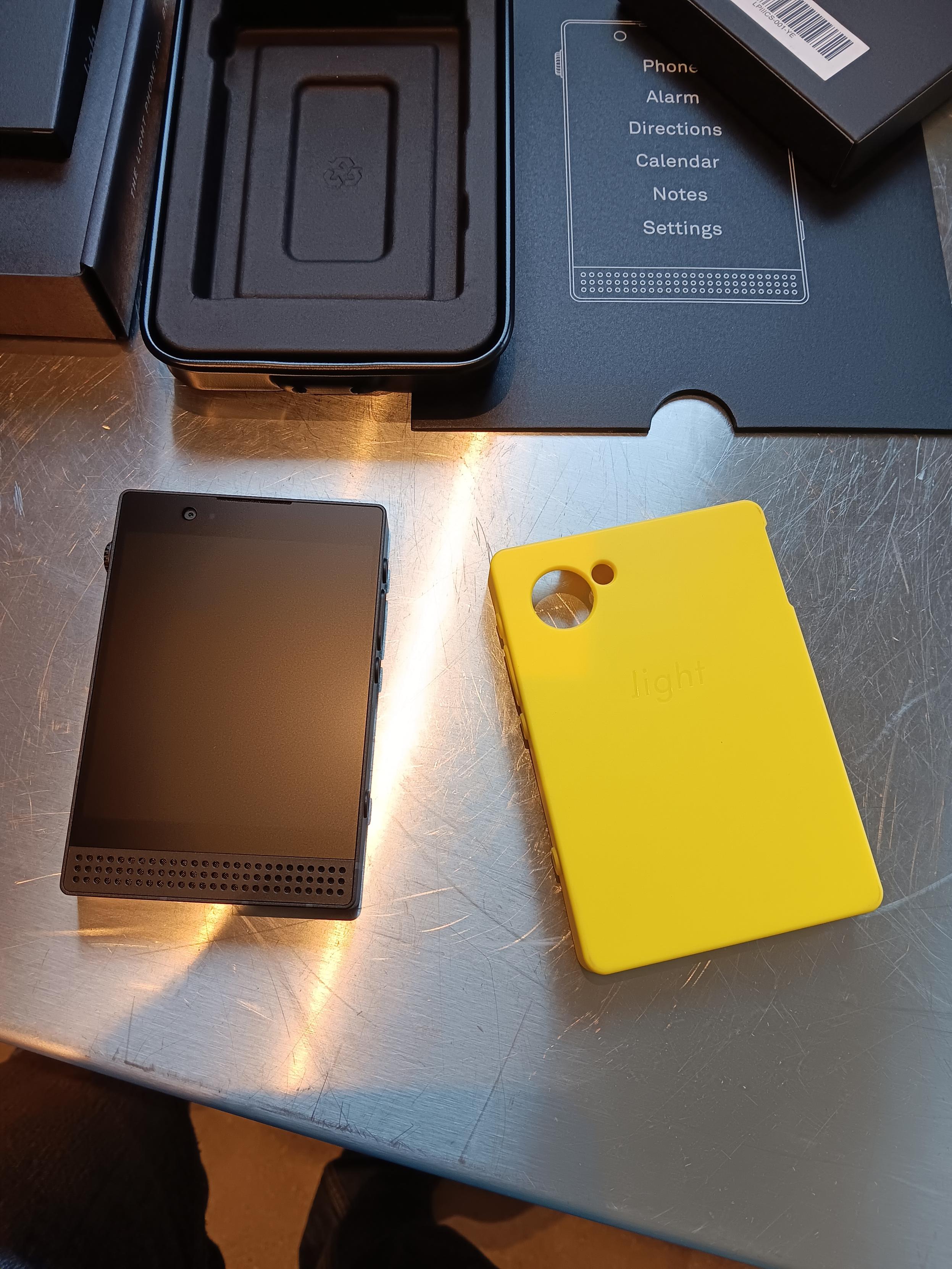 The lightphone next to a protective yellow case.