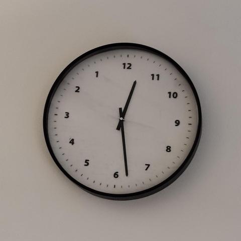 A wall clock with the numbers running widdershins