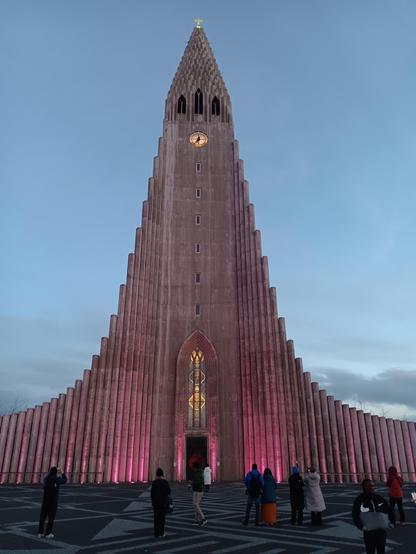 Hallgrímskirkja Church in the evening, lit with pink lights. 