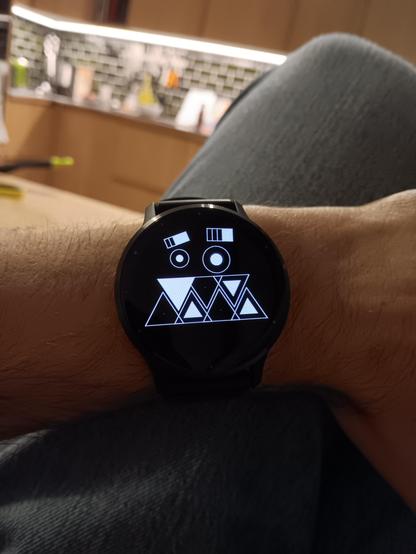 A watch face on a smart watch that has a weird face with two lines of teeth. 3 teeth on top and 4 below. The teeth have 3 possible states, black, half white and fully white.