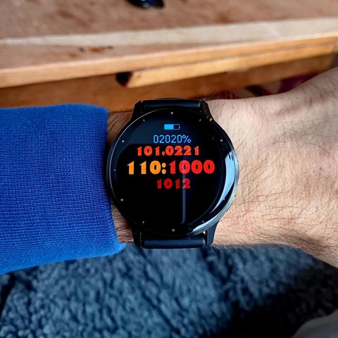 A watch dial on a Garmin Venu 3 with the information encoded in ternary using digits in a range of colours. 

02020 = 60%
101 = 10 (Oct)
0221 = 25th Day
110 = 12 Hours
1000 = 27 Minutes
1012 = 32 Seconds