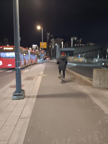 Man on a 20" wheeled unicycle cycling in the evening. 
