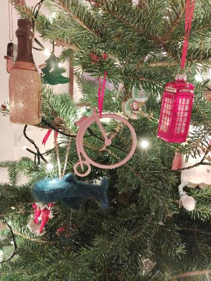A Christmas tree with a penny farthing decoration in the foreground