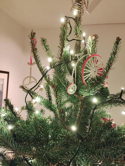 More decorations on a Christmas tree, one unicycle and one penny farthing.