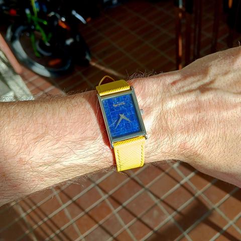 Tank style, rectangular watch with lapis lazuli tiles on the face. With a yellow leather strap. 