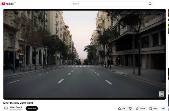 A totally empty road in a city from the driver's perspective. This is a still image taken from a Volvo EX90 advert on Youtube.
