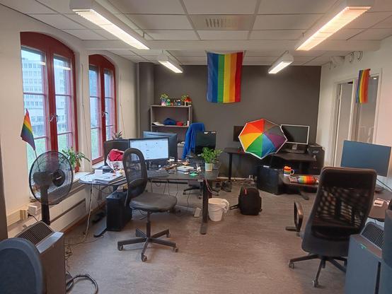Office enivrioment full on rainbow flags or things decorated with rainbows