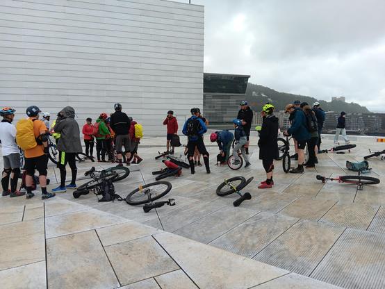 Lots of people standing around unicycles