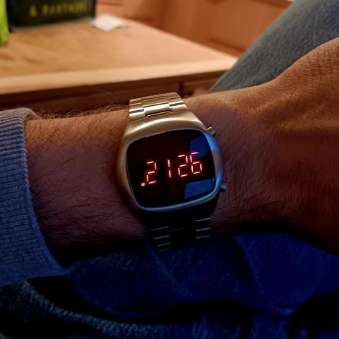 Metal watch with red, LED, numerals showing the time as 21:26