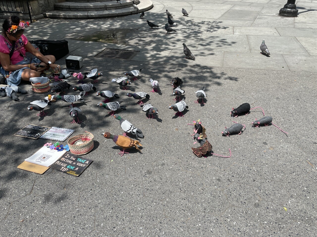 Flock of handmade pigeons and a few rats. Behind them are some live pigeons.