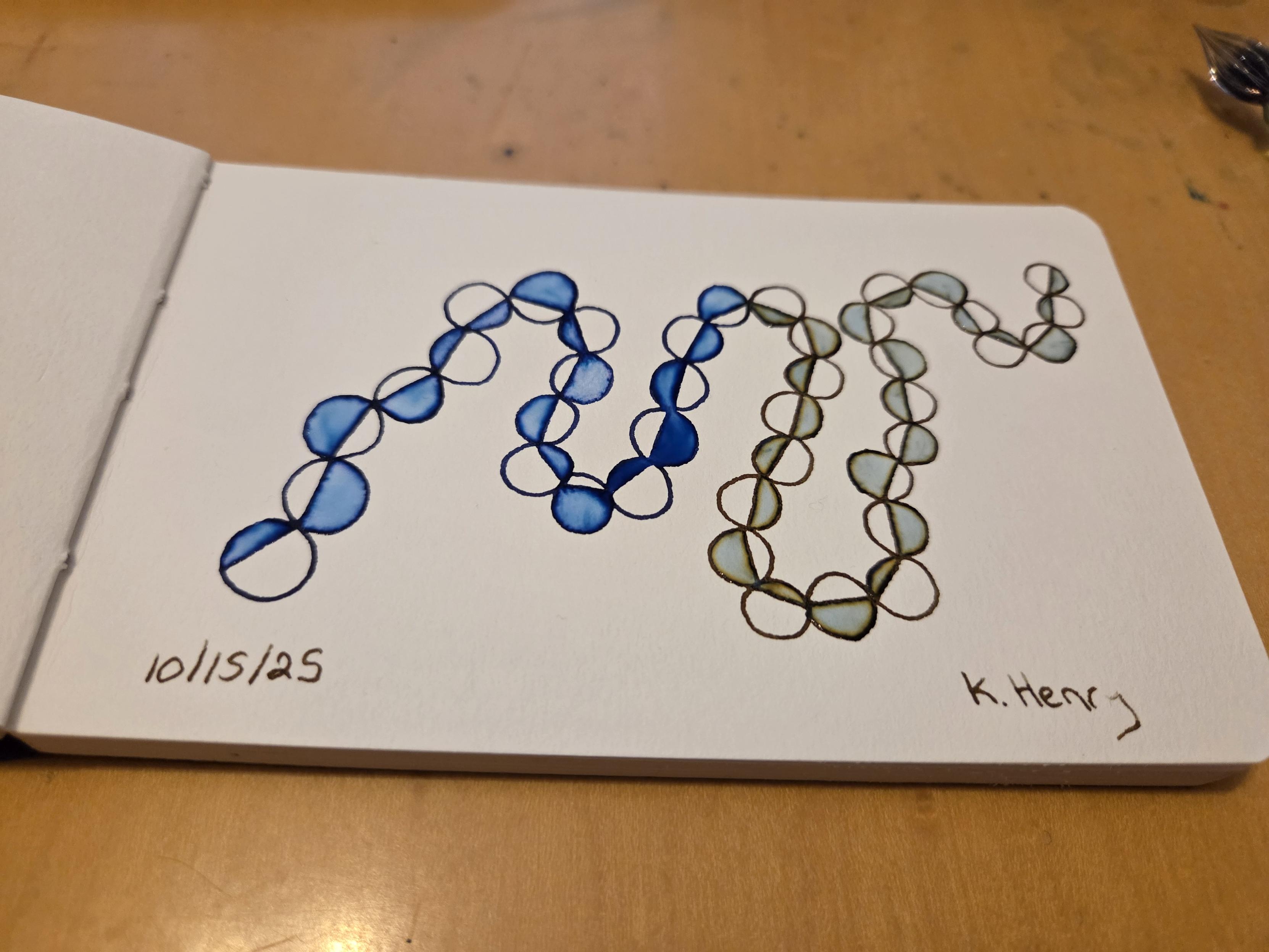 Hand drawn generative/procedural art in ink on an open page of my sketchbook. The abstract pattern looks a bit like a string of beads.