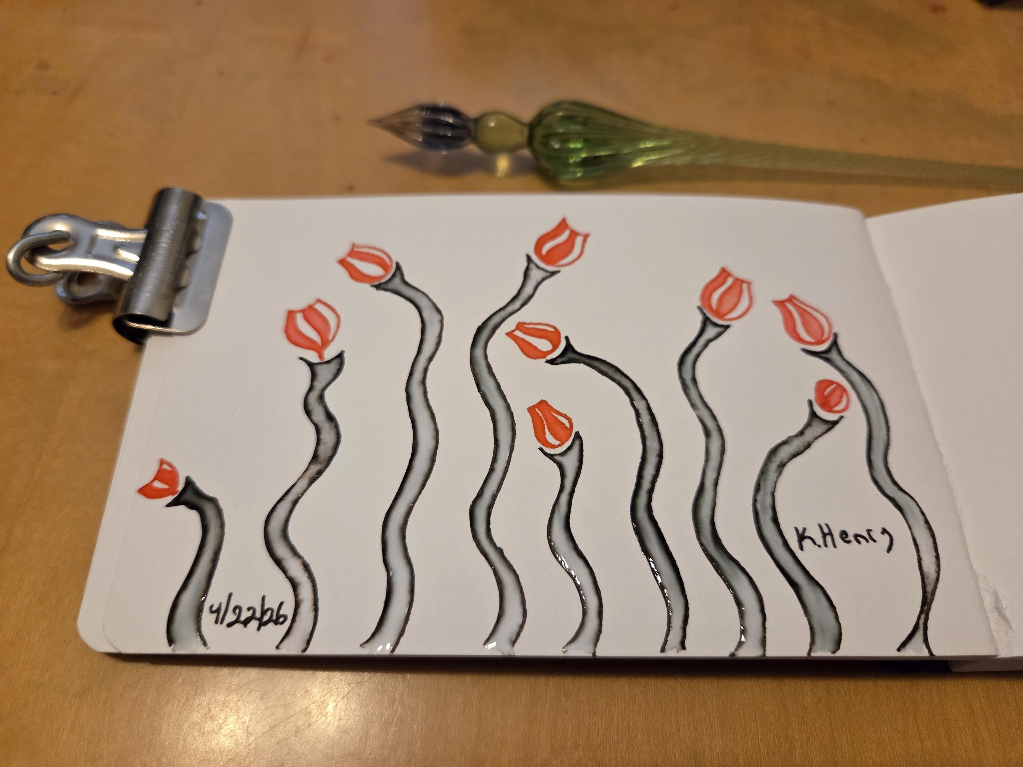 Hand drawn generative/procedural art in ink on an open page of my sketchbook. The abstract pattern looks a bit like some wavy stems with little flower bud at the tops. There is a binder clip holding my sketchbook open, and my glass dipping pen is next to it.