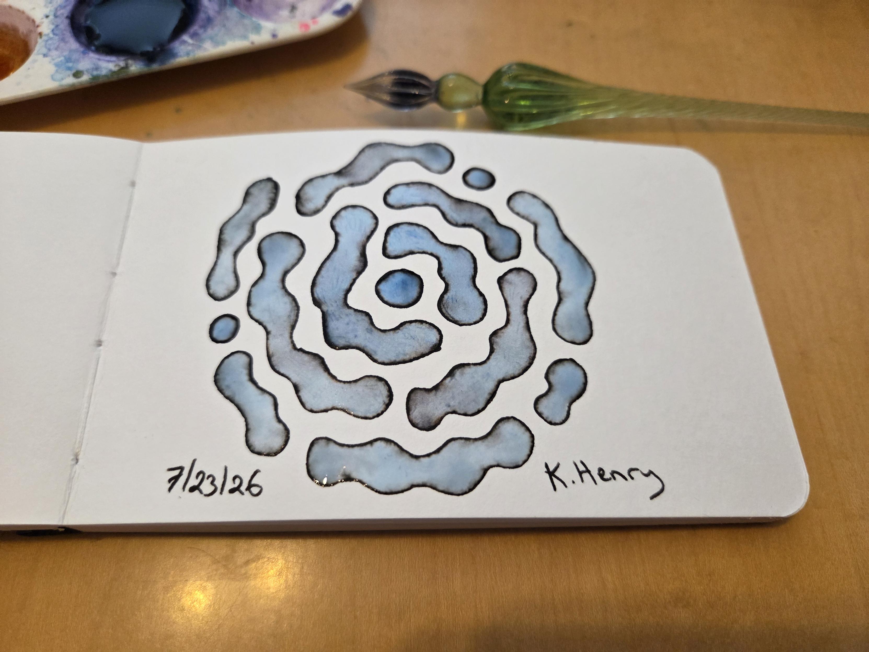 Hand drawn generative/procedural art in ink on an open page of my sketchbook. The abstract pattern is difficult to describe. My glass dipping pen is next to my sketchbook.