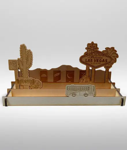 A lazer cut wooden display stand for Desert Bus DBloons with signs for Tuscon and Las Vegas and the four shift banners.