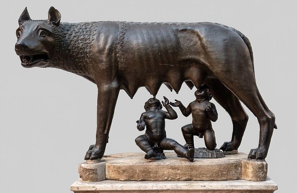 Sculpture en bronze de la Louve capitoline, symbole de Rome, montrant une louve allaitant les jumeaux mythiques Romulus et Remus. Cette œuvre emblématique des musées du Capitole est mise en valeur par un fond neutre, soulignant ses détails minutieux et son importance historique.