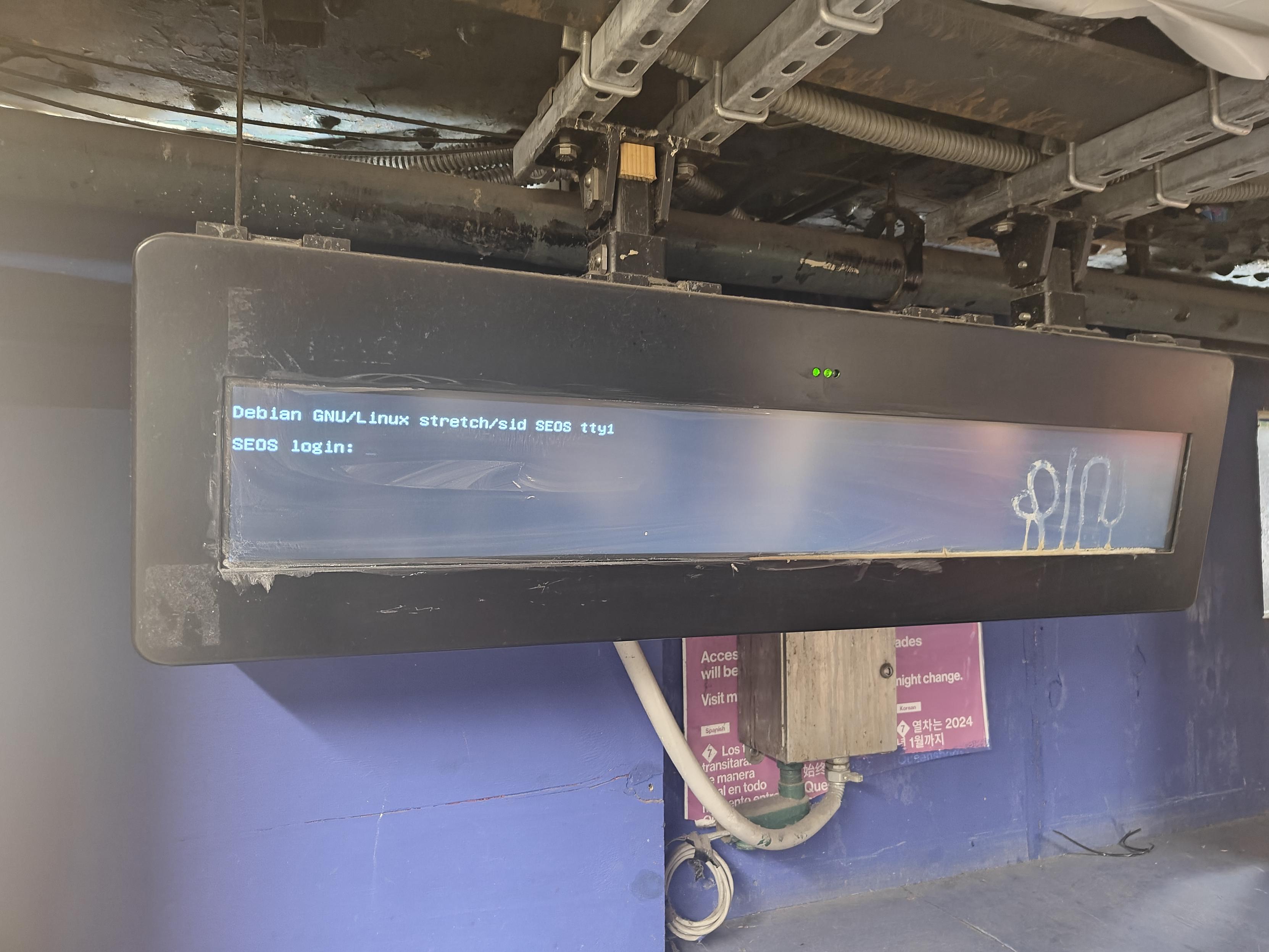 NYC subway time display showing the Debian GNU/Linux stretch/sid console login screen