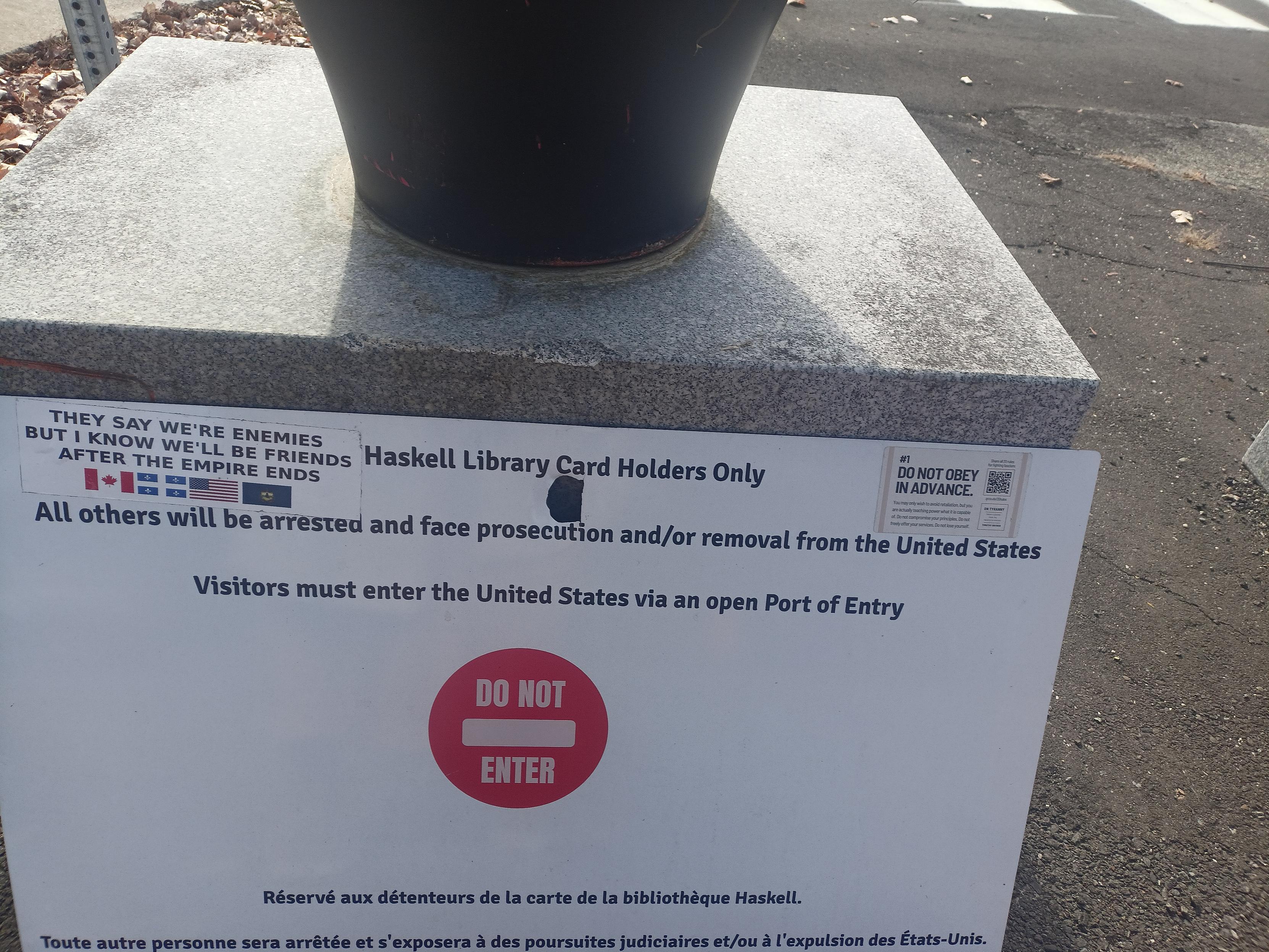 "They say we're enemies but I know we'll be friends after the empire ends" sticker on the "Do not enter" sign