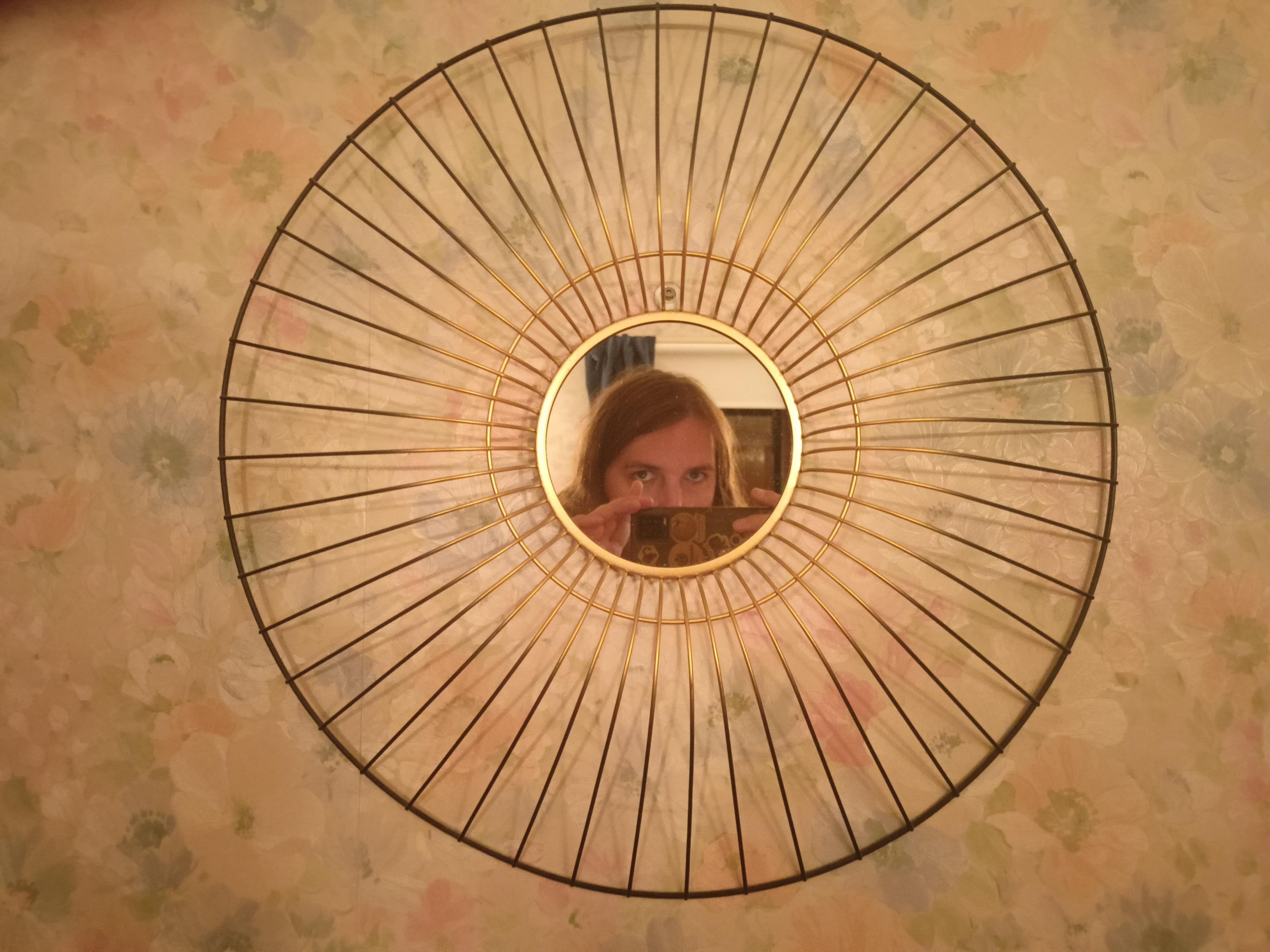 Reflect of myself in a small very circular mirror.