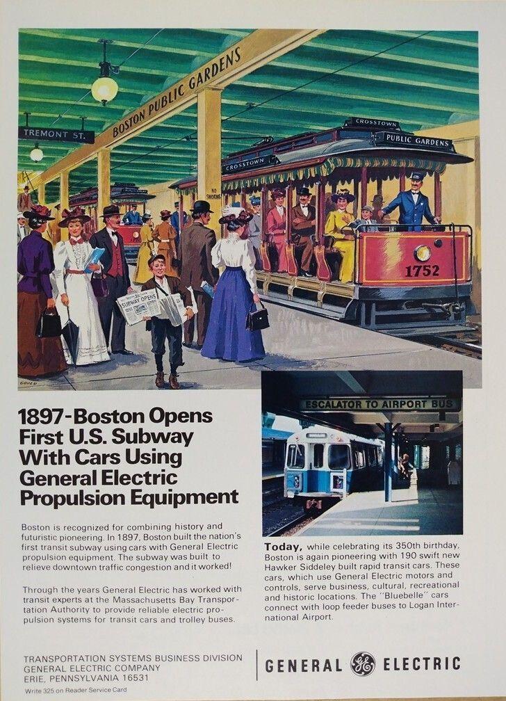 This print advertisement documents Boston’s transit history in two eras. The upper illustration depicts the opening period of the Tremont Street Subway in 1897, recognized as the first subway in the United States. The scene is set at the Boston Public Gardens incline portal. Overhead signs read “Boston Public Gardens” and “Tremont St.” An open electric streetcar marked “Crosstown – Public Gardens” stands at the platform. The car number 1752 is visible on the front panel. The streetcar features open sides, longitudinal seating, and a motorman standing at the front controls. The platform canopy is supported by columns and lit by round globe lamps. Passengers are shown in period clothing typical of the late 19th century.

The printed headline states: “1897 – Boston Opens First U.S. Subway With Cars Using General Electric Propulsion Equipment.” The accompanying text explains that Boston built the subway to relieve downtown congestion and that the cars used General Electric propulsion systems.

In the lower right corner, a circa 1980 Massachusetts Bay Transportation Authority (MBTA) Blue Line rapid transit car is shown at an underground station. A sign above the platform reads “Escalator to Airport Bus.” The caption text notes that Hawker Siddeley built rapid transit cars equipped with General Electric motors and controls.
