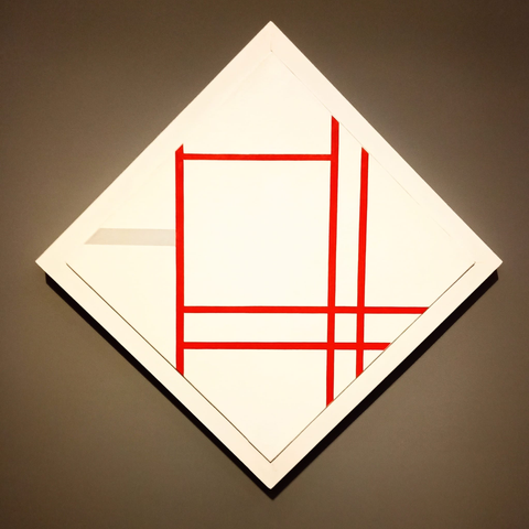 ein auf der Spitze stehendes Quadrat, weiße Fläche, mit drei waagerechten und drei senkrechten roten Linien, die ein großflächiges Raster bilden