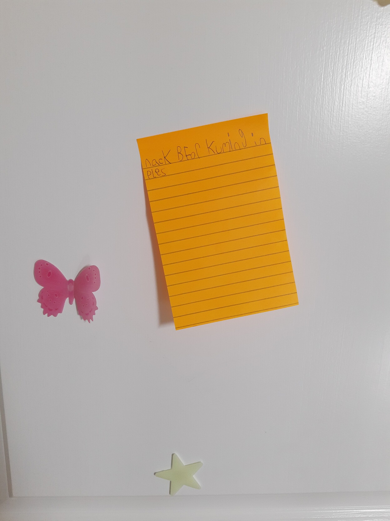 An orange post it note on a door that says "nacK BFor Kuming in PLes"