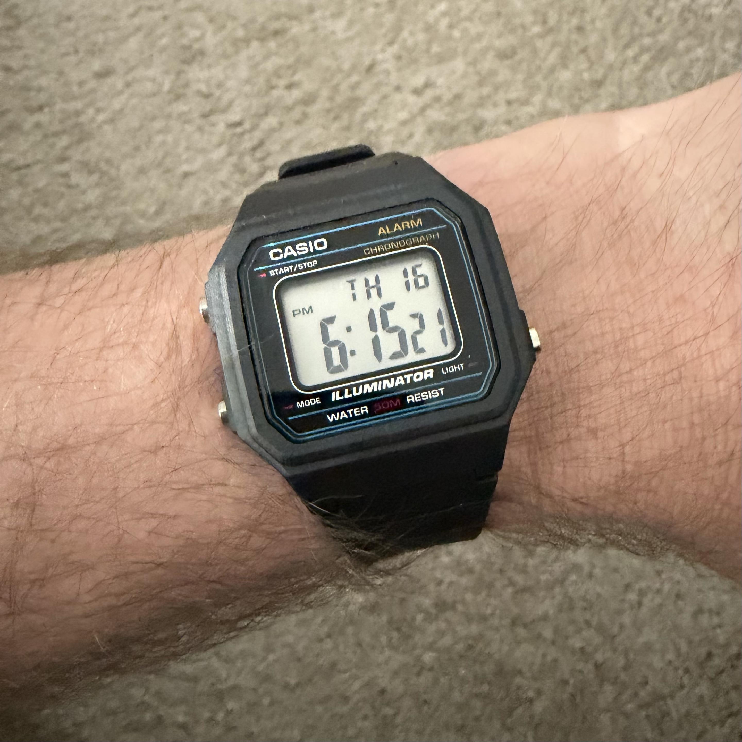 A picture of my wrist sporting a black Casio CAS25 wristwatch.